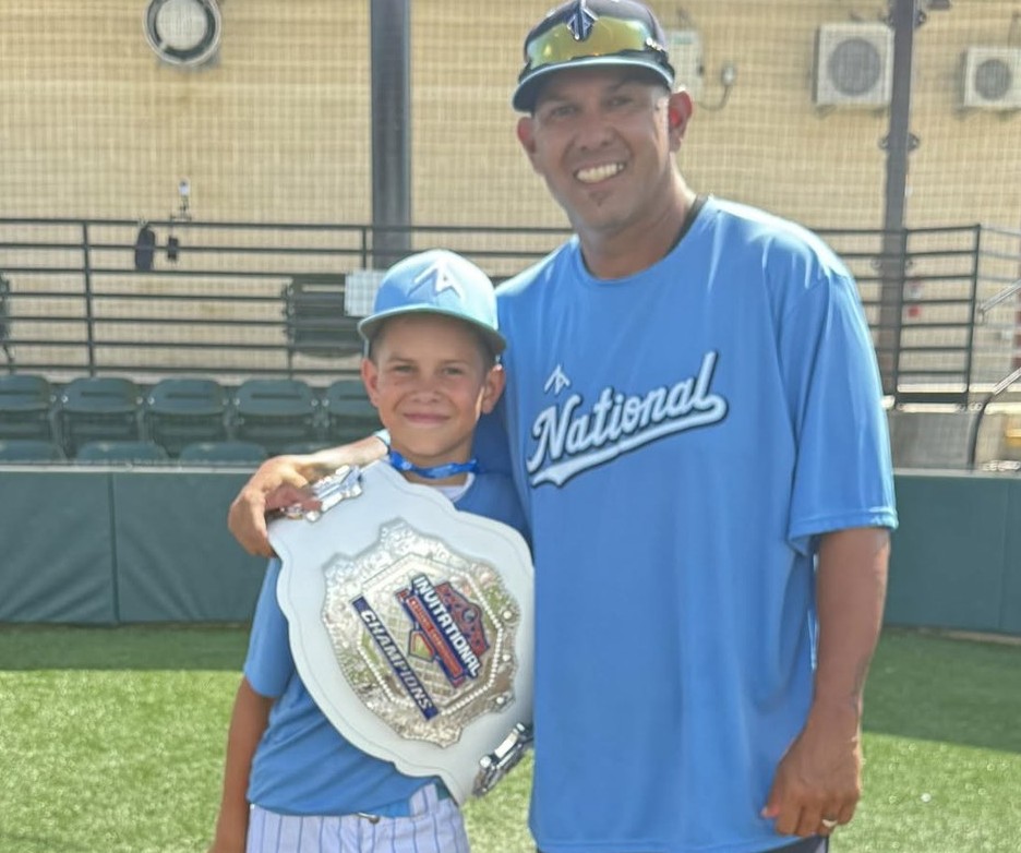 Coach PJ Garcia and a player with the championship belt